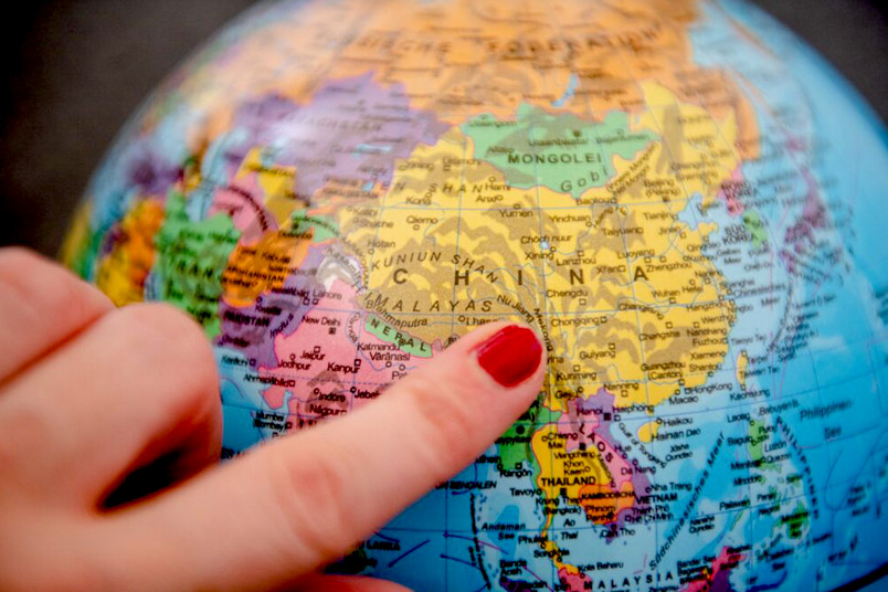 Finger zeigt auf China auf einem Globus.