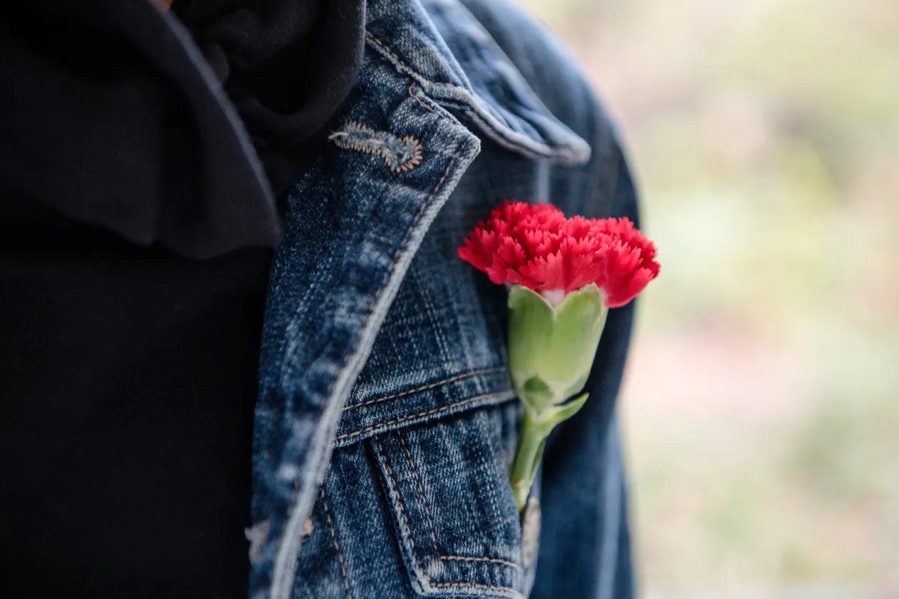 Eine rote Nelke im Knopfloch einer Jacke