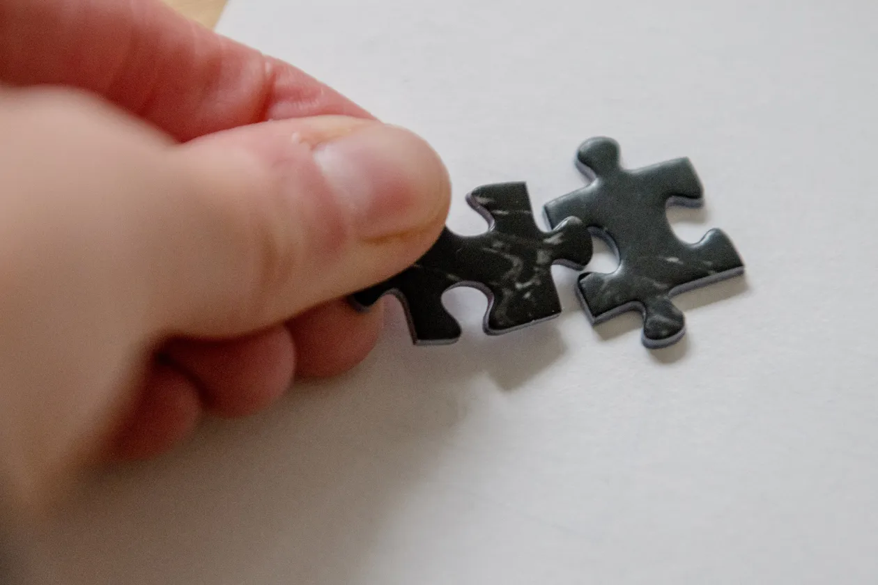 Hand legt ein Puzzleteil