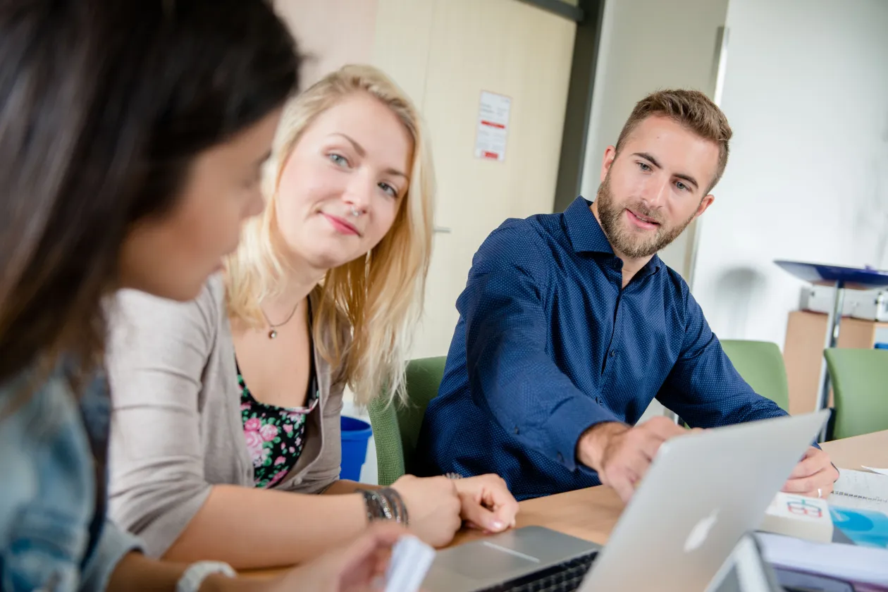 Junge Forscher mit Büchern und Laptops