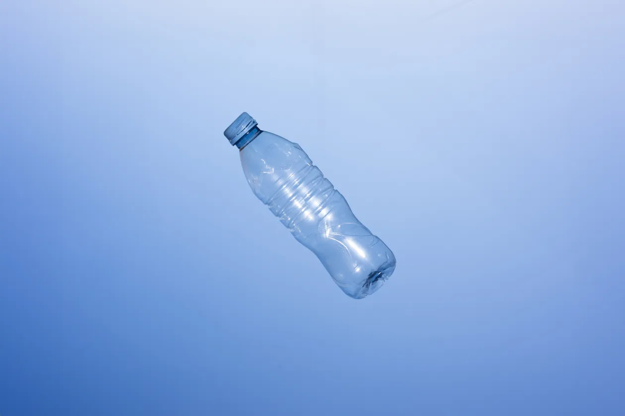 Einzelne PET-Flasche vor blauem Hintergrund