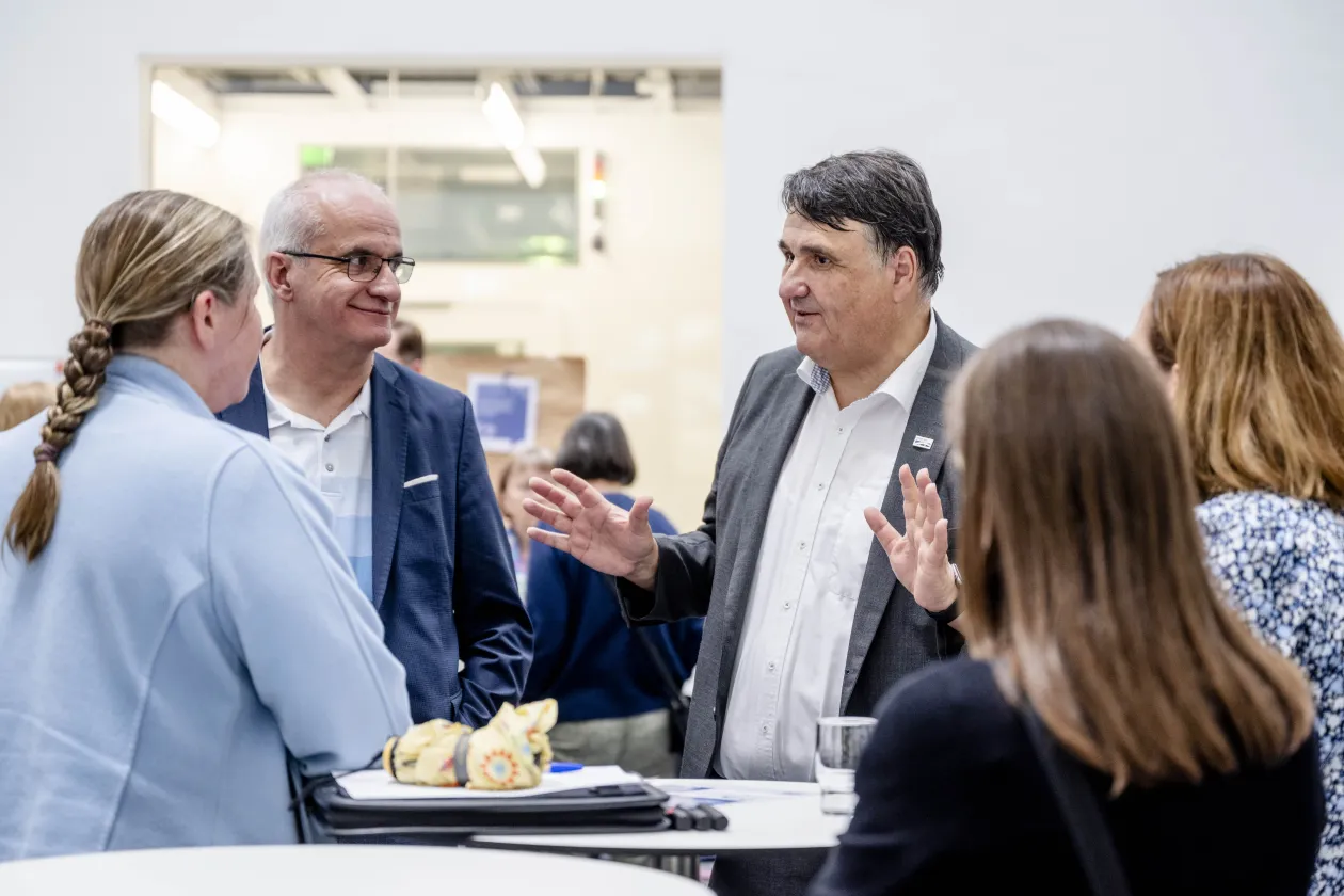 Die Rektoren Paul und Bayer im Gespräch mit mehreren Personen