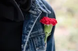 Eine rote Nelke im Knopfloch einer Jacke