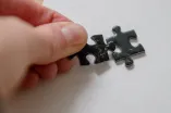 Hand legt ein Puzzleteil