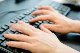 Hände tippen auf einer Tastatur