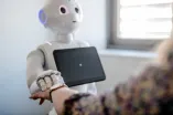 Roboter streichelt einer Frau die Hand