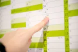 Ein Finger zeigt auf einen Wandkalender