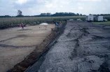 Eine archäologische Grabung am Rande eines Maisfelds