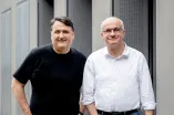 Zwei Männer mit schwarzem und weißem Hemd lächeln