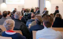 Menschen in einem Tagungsraum von hinten