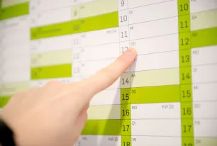 Ein Finger zeigt auf einen Wandkalender