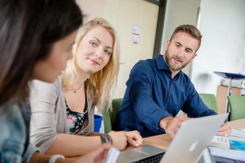 Junge Forscher mit Büchern und Laptops