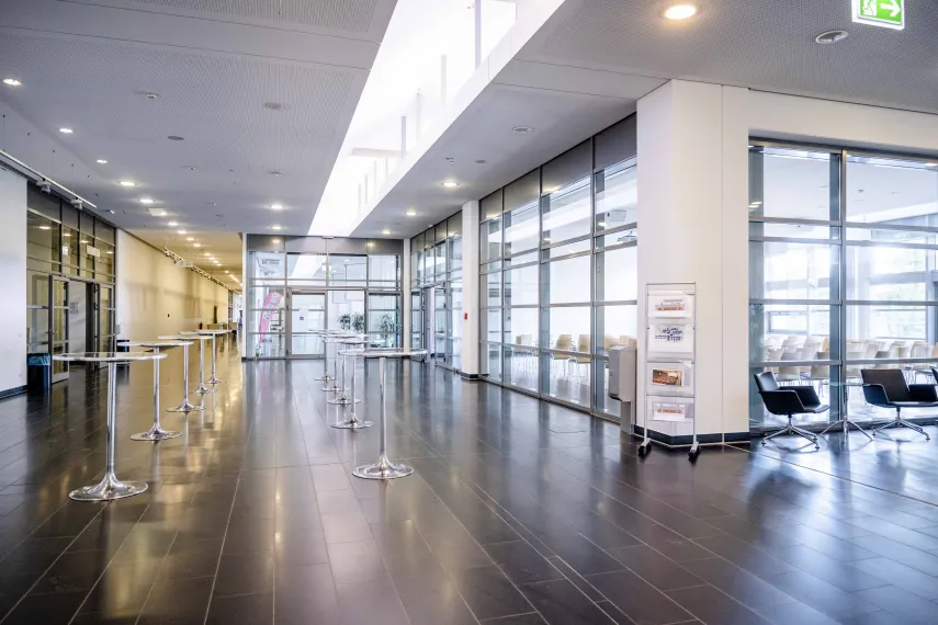 Foto: Foyer mit Stehtischen und Blick in Saal 1 im Veranstaltungszentrum der Ruhr-Universität Bochum