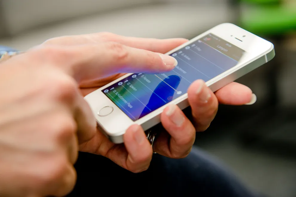 Eine Hand tippt auf einem Smartphone.