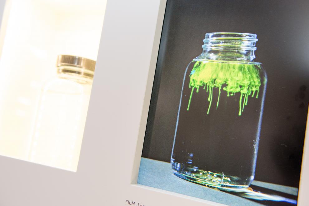 Ein Monitor zeigt, wie sich eine grüne Flüssigkeit in einer transparenten Flüssigkeit löst.