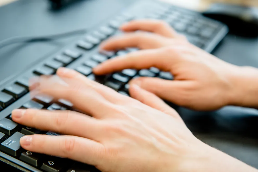 Hands tapping on a keyboard