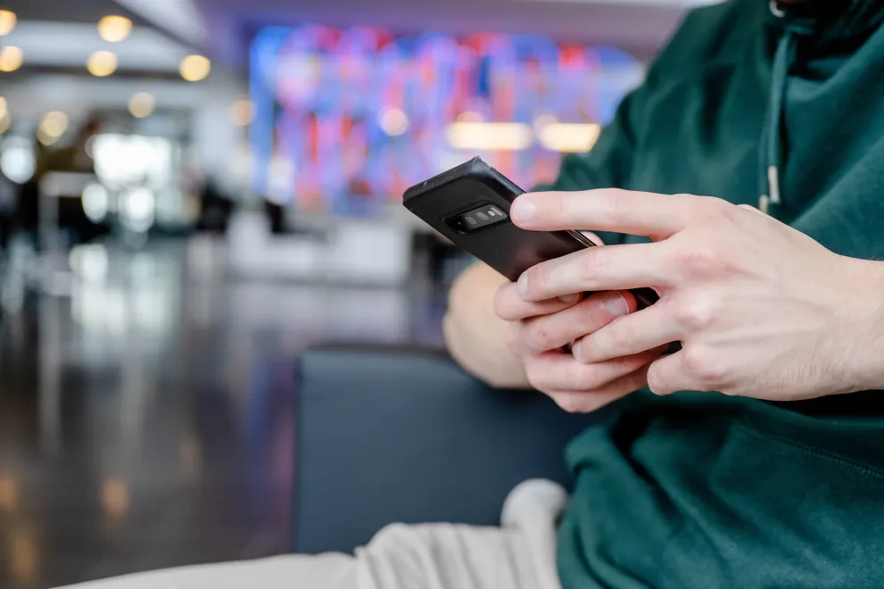 Eine Person hält ein Smartphone in der Hand.