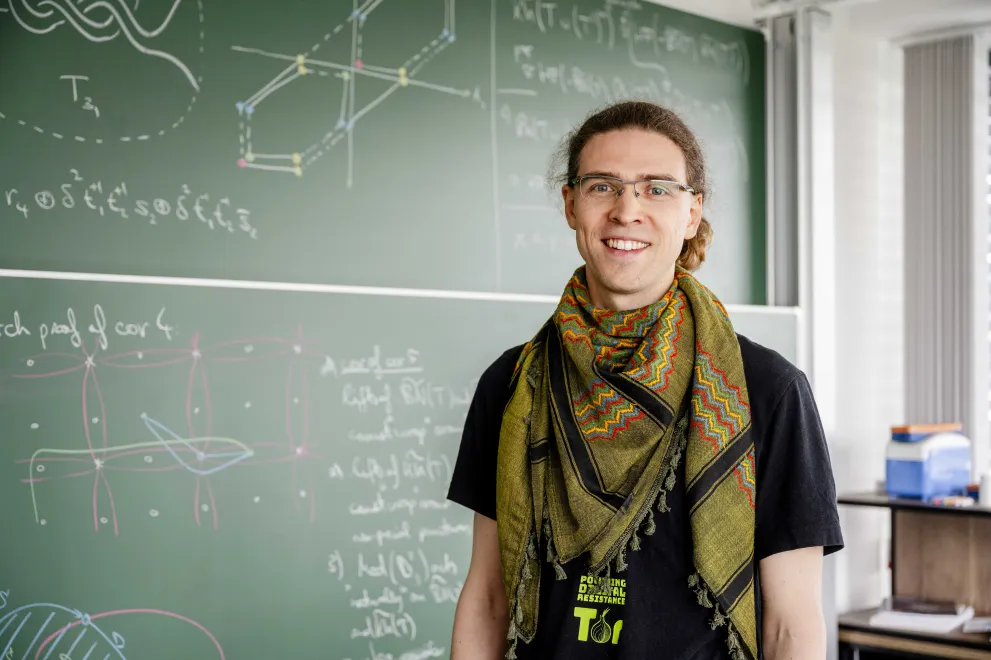 Person vor Tafel mit mathematischen Zeichnungen