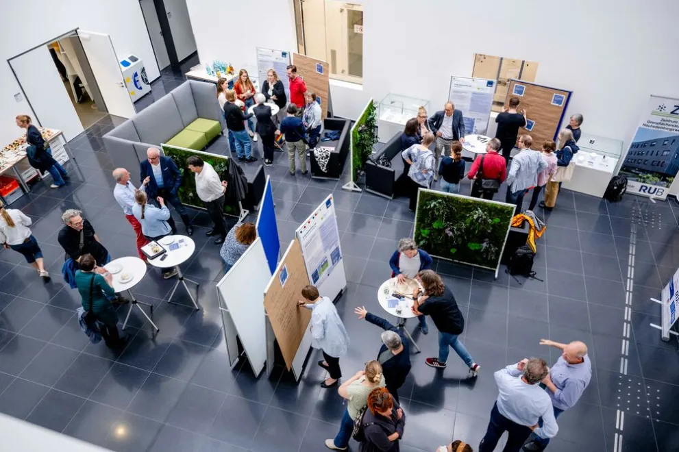 Blick aus der Vogelperspektive auf verschiedene Gesprächskreise an Postern