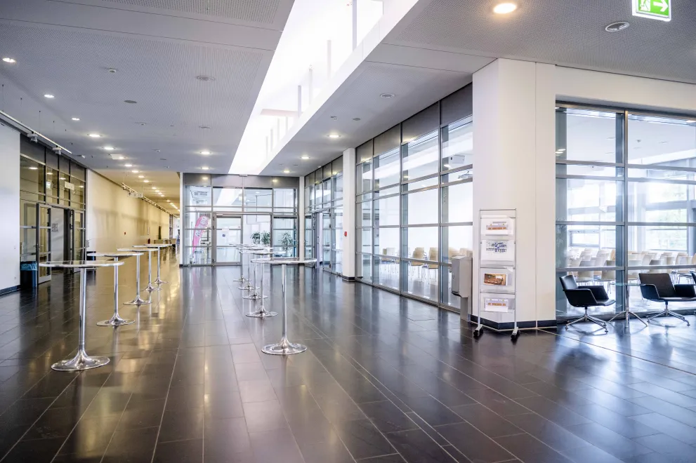 Foto: Foyer mit Stehtischen und Blick in Saal 1 im Veranstaltungszentrum der Ruhr-Universität Bochum