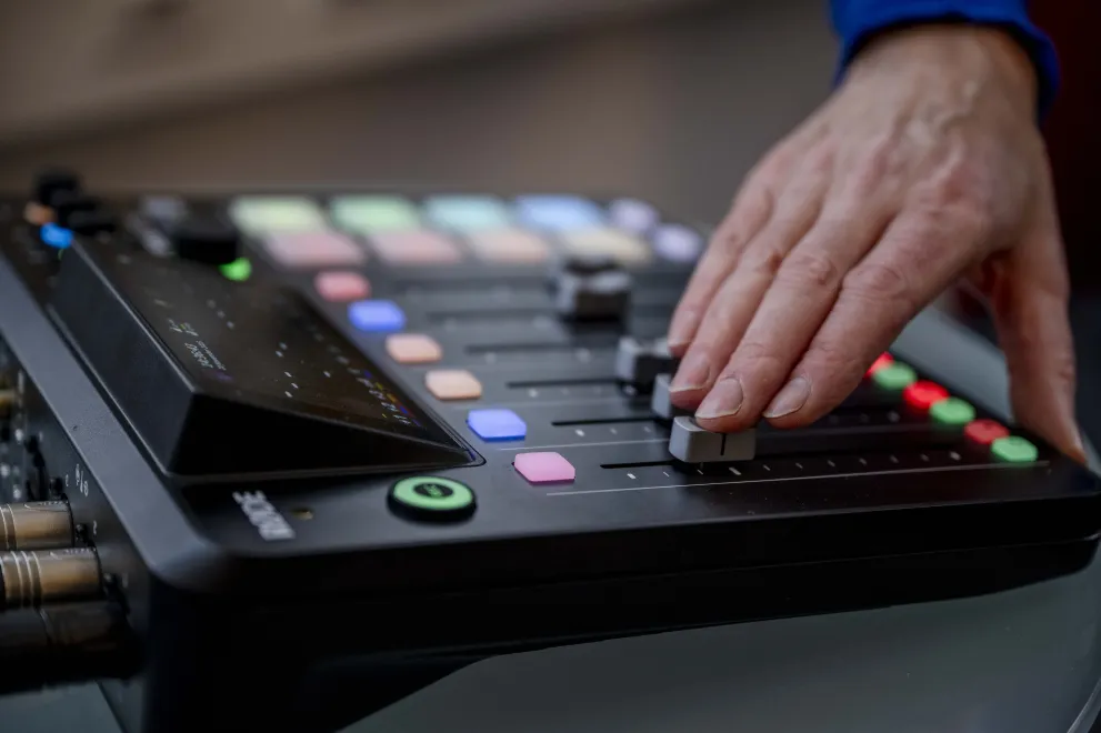 Hand, die einen Regler an einem Aufnahmegerät betätigt