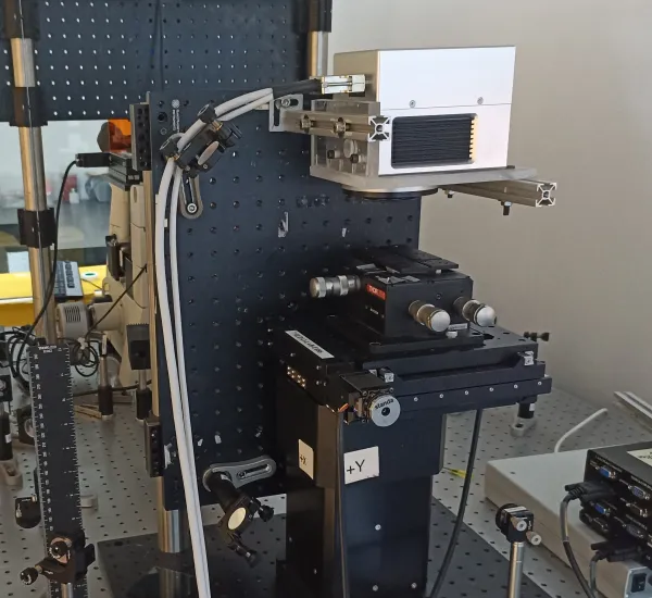 Photograph of a typical laser-material processing setup, where a high-speed scanner controls the interaction point of the laser on the material.